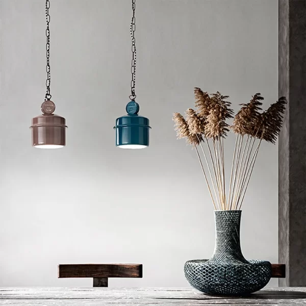 sospensione in ceramica laccata stile rustico color fango su tavolo con pianta