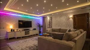 soggiorno illuminato con strisce led colorate e punti led